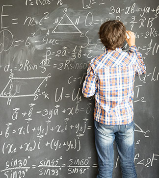 Student writes equations on a blackboard